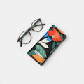 Funda de gafas Ophelia de tuá e muá con estampado floral vibrante sobre fondo negro, cierre a presión.