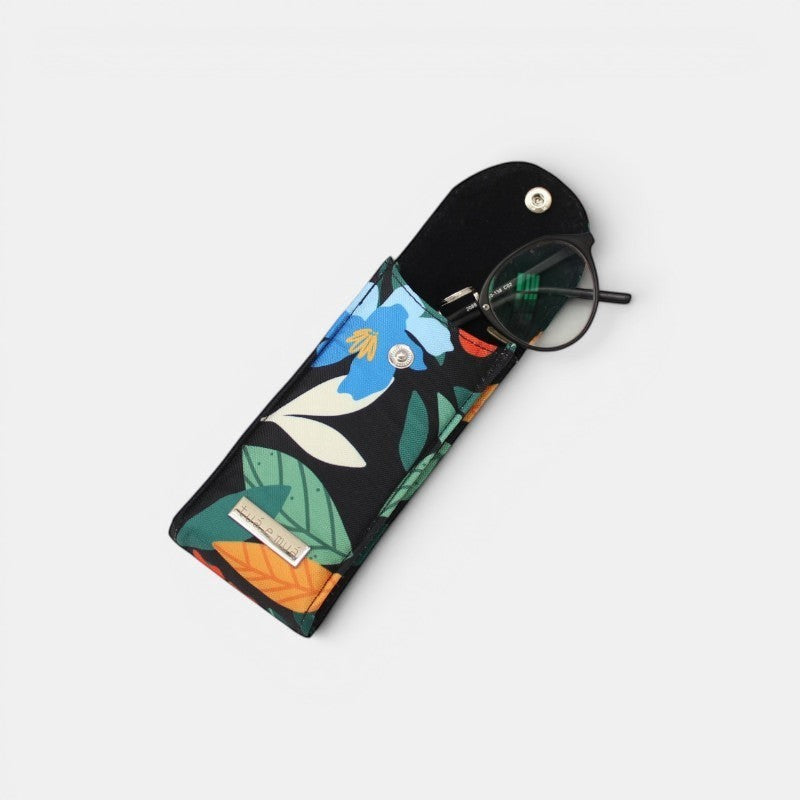 Funda de gafas tuá e muá con estampado floral azul y verde sobre fondo negro. Cierre a presión.