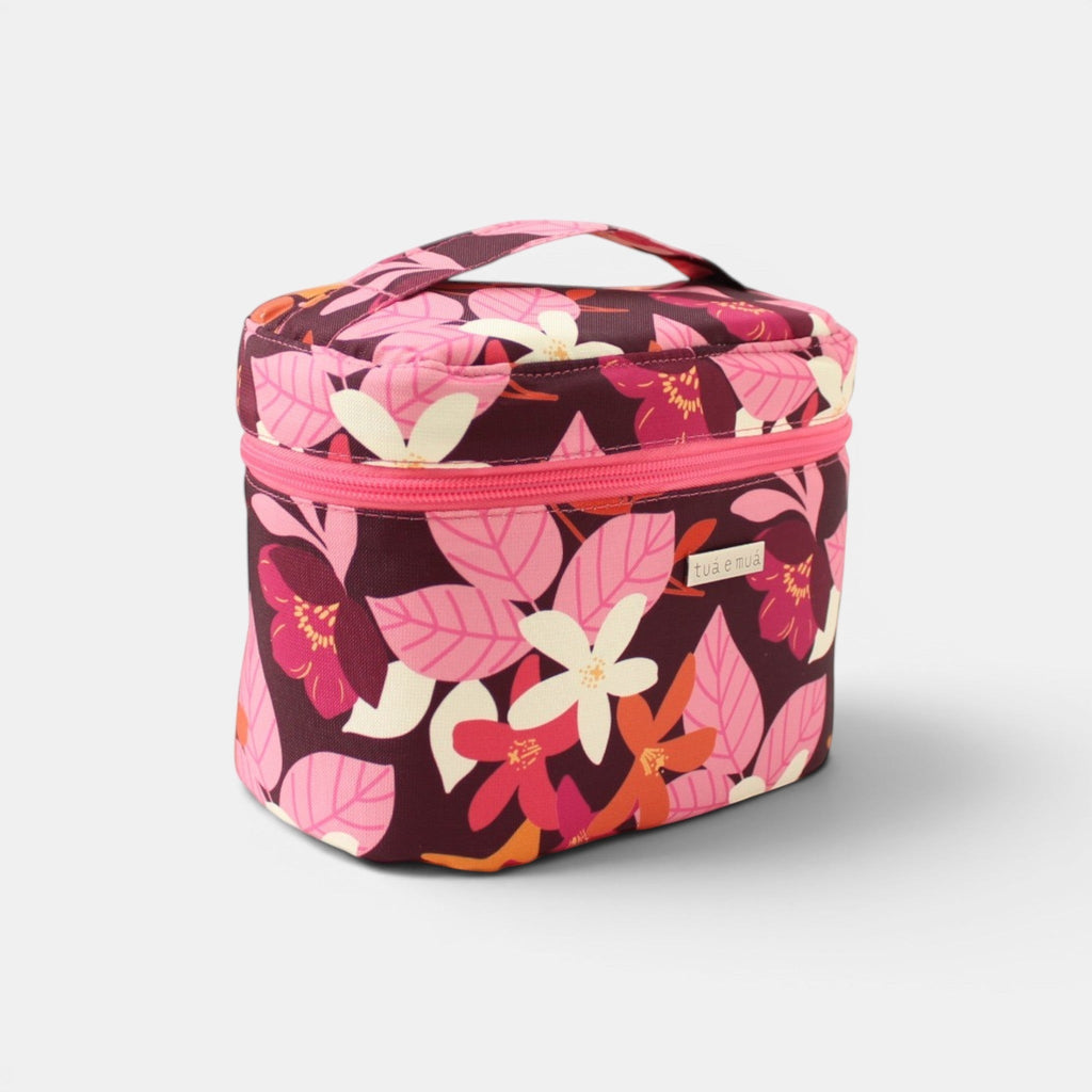 Neceser cilíndrico tuá e muá con estampado floral en burdeos, rosa, fucsia, blanco y naranja. Asa superior y cremallera fucsia.