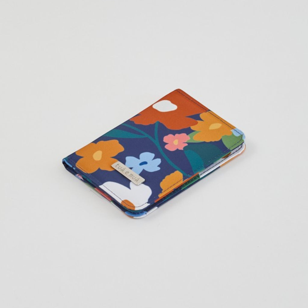 tuá e muá Porta Pasaporte Flora, tarjetero de lona impermeable con estampado floral azul, naranja y blanco.