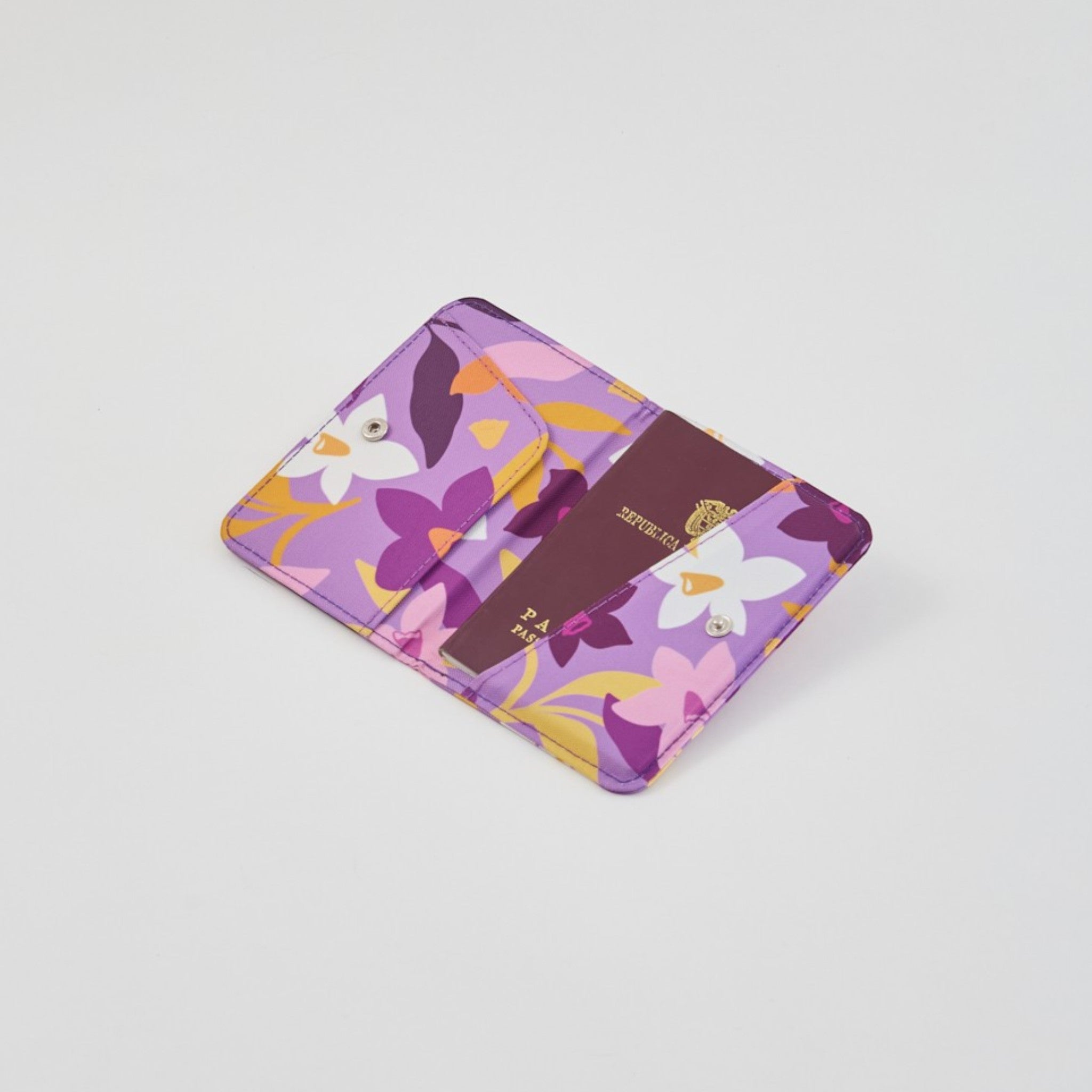 tuá e muá Porta Pasaporte Narcisa morado con estampado floral, lona impermeable con compartimentos para pasaporte y tarjetas.